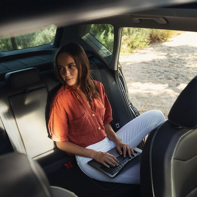 Frau sitzt auf der Rückbank eines SEAT Ateca