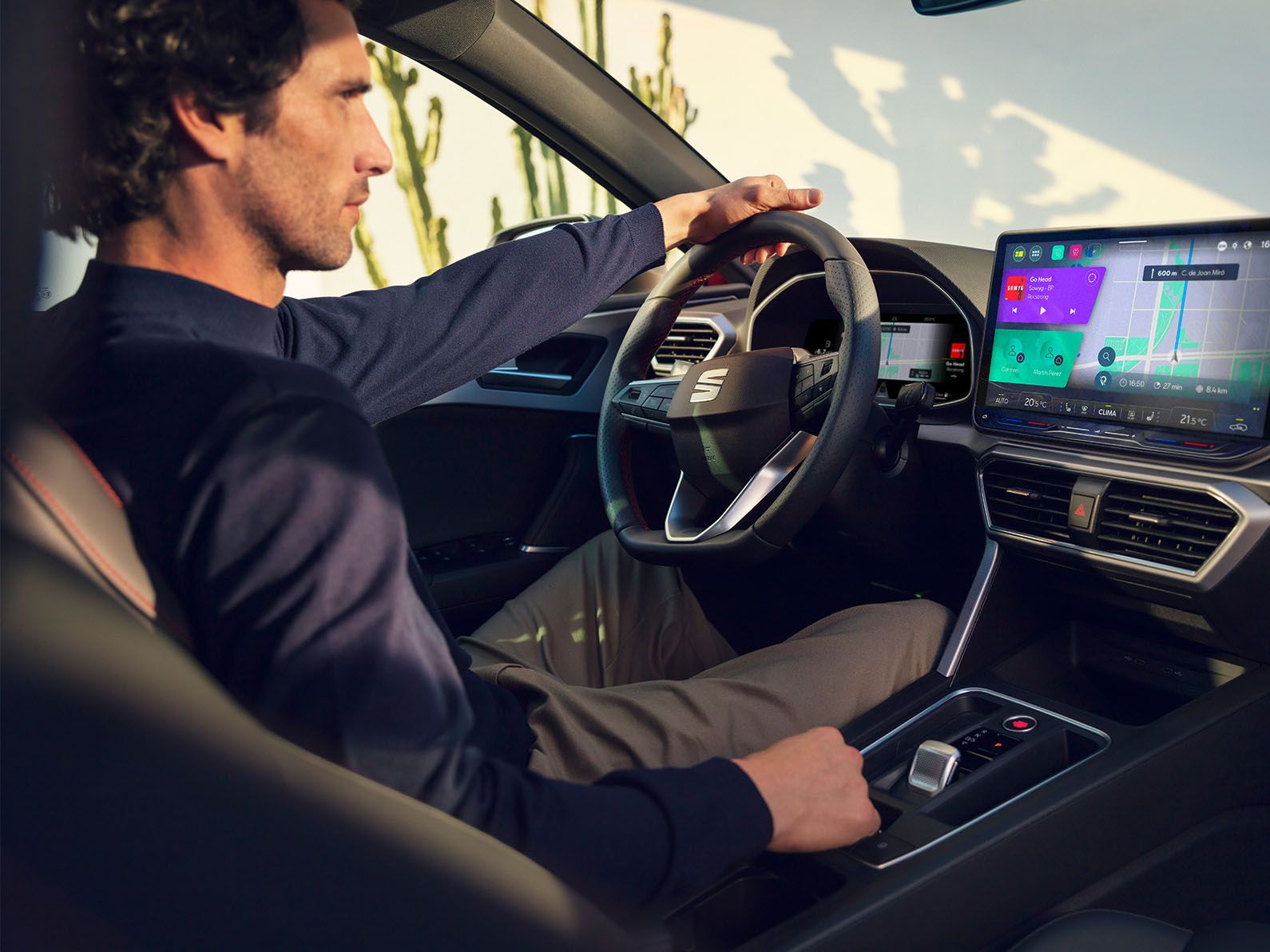 Innenraumansicht wie ein Mann in einem SEAT Leon sitzt und das Navigationssystem am Bildschirm nutzt