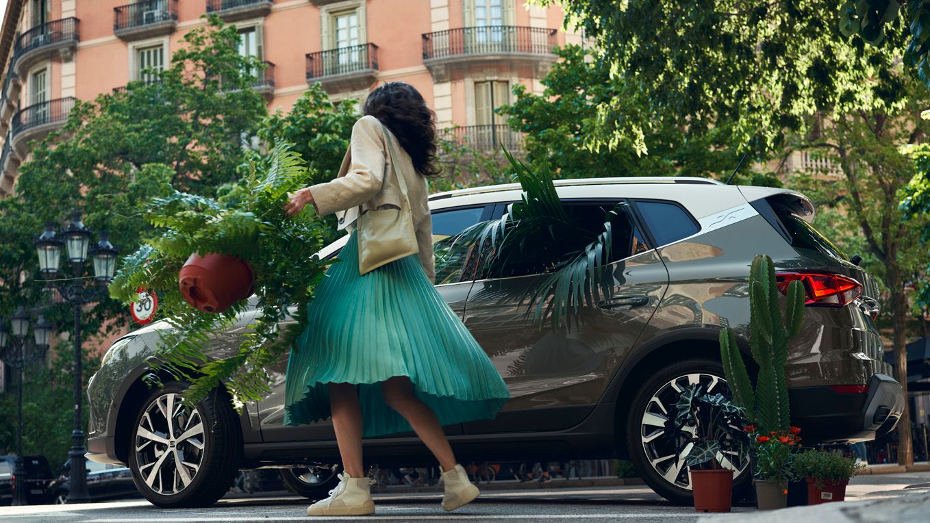 Eine Frau öffnet die Tür eines SEAT Arona