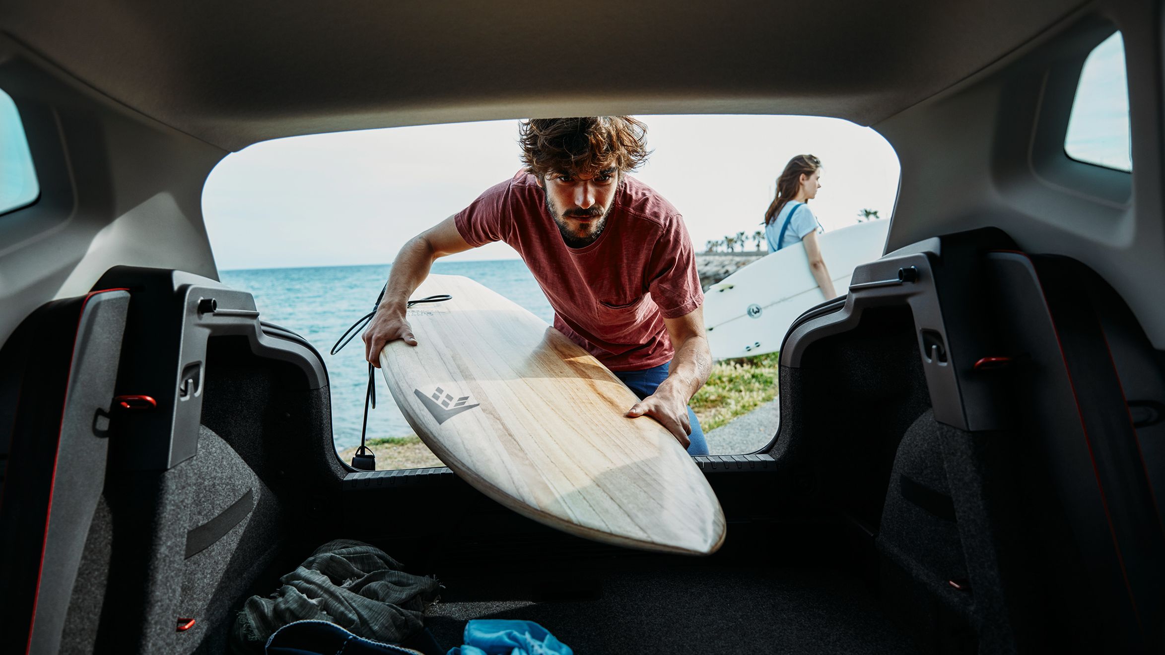 SEAT Service – homem coloca uma prancha de surf numa bagageira de um SEAT