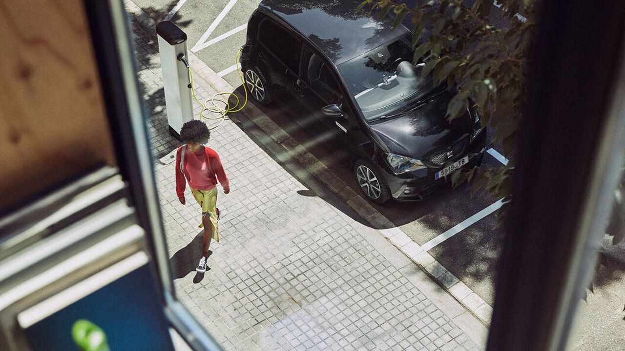 Ein SEAT Mii ist am Straßenrand an eine Ladesäule angeschlossen und wird gerade aufgeladen