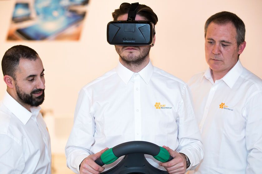Drei Mitarbeiter lernen mit Virtual-Reality-Headset und Lenkrad