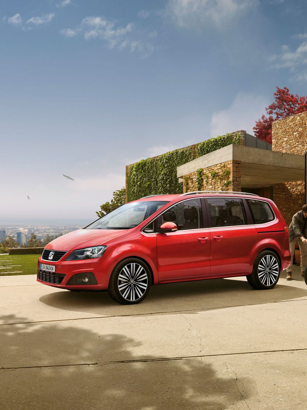 Ein roter SEAT Alhambra steht in der Einfahrt eines Wohnhauses