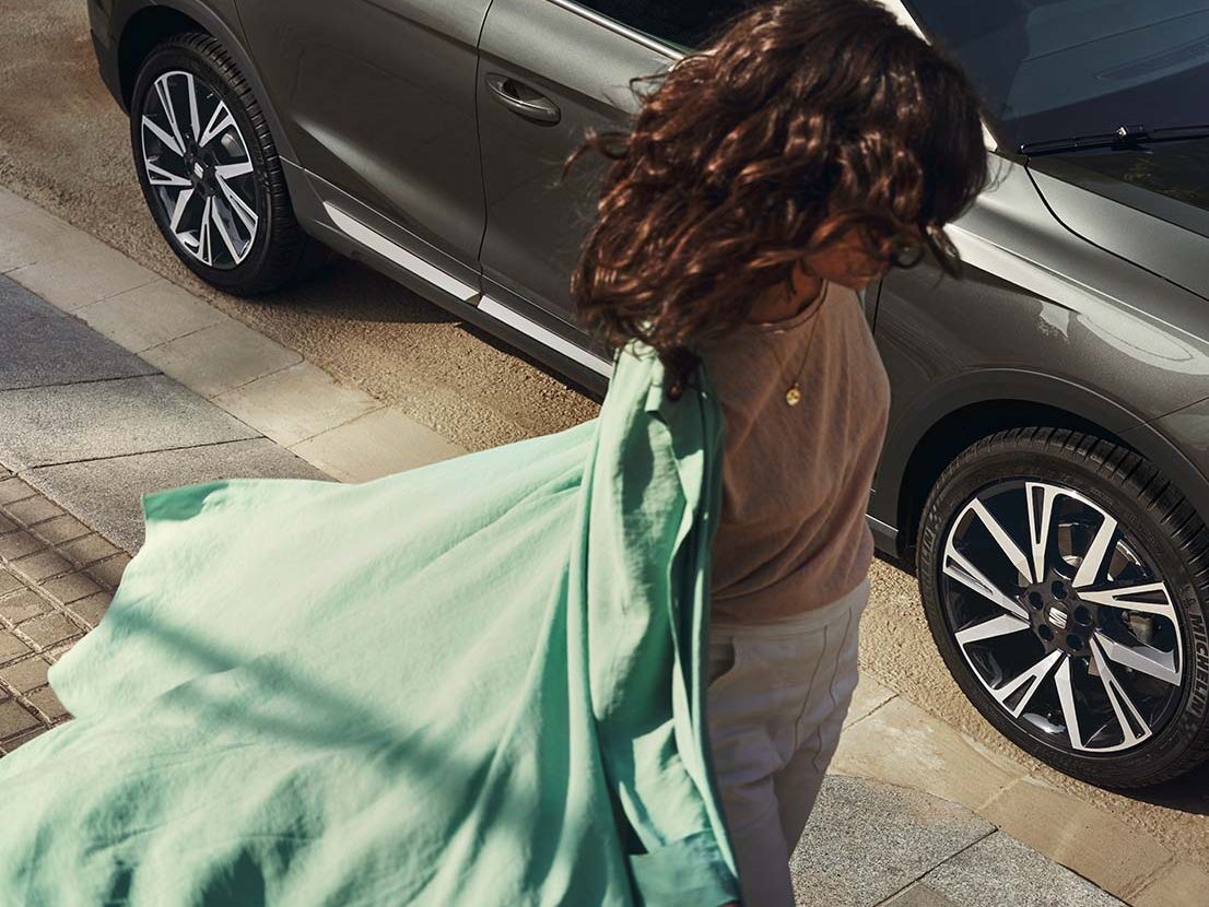 Eine Frau geht am SEAT Arona vorbei
