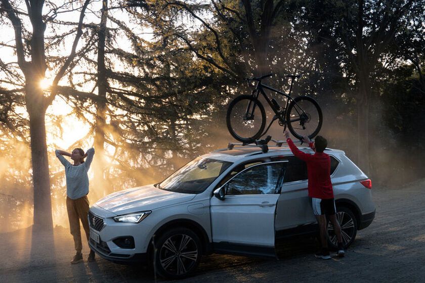 Zu sehen ist ein SEAT Ateca in Fahrt, auf den Dachträgern befindet sich ein Fahrrad