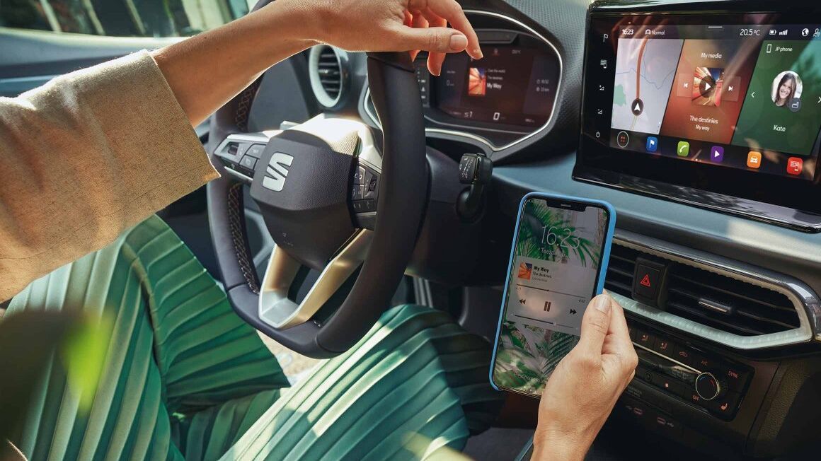 Frau sitzt im Auto und verwendet SEAT Full Link