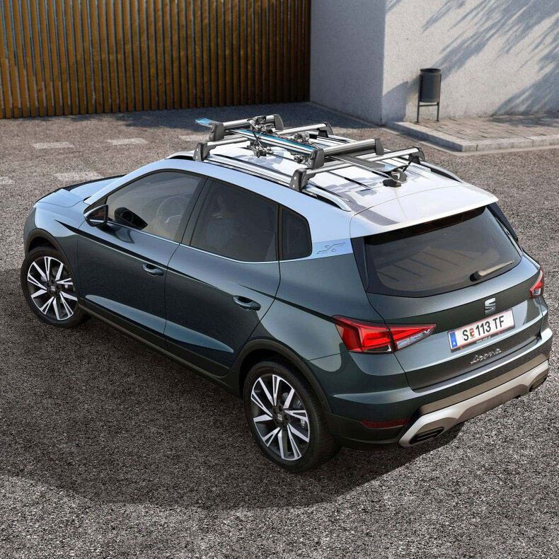 Ein grauer SEAT Arona mit weißem Dach und montiertem Skiträger