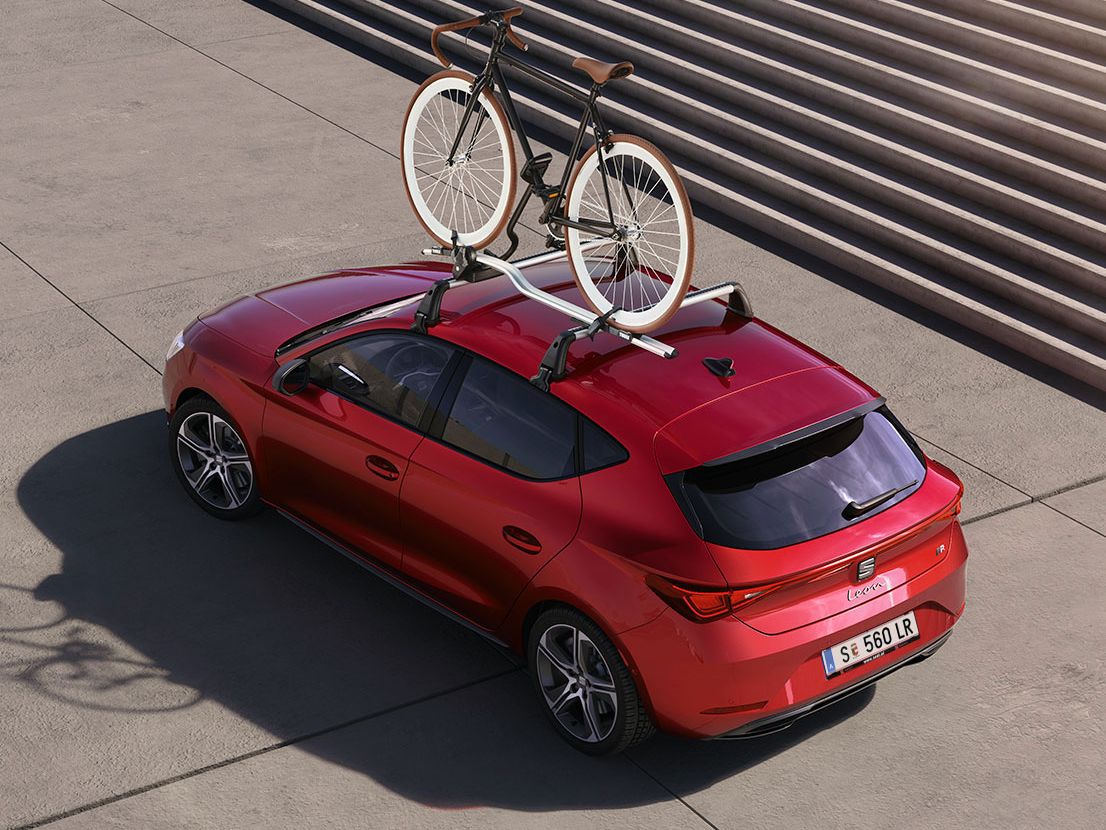 roter SEAT Leon mit Fahrrad auf dem Dach