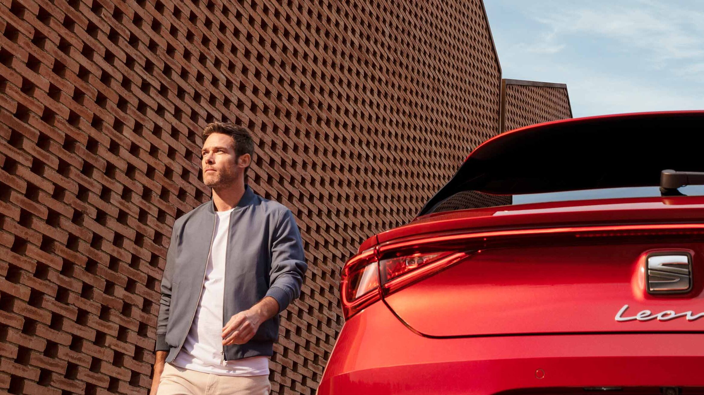 Nahaufnahme des Hecks eines SEAT Leon, während ein Mann im Hintergrund auf die Kamera zugeht