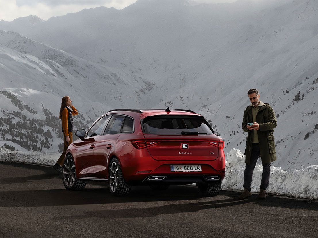 Casal a ver a montanha junto ao SEAT Leon vermelho desire