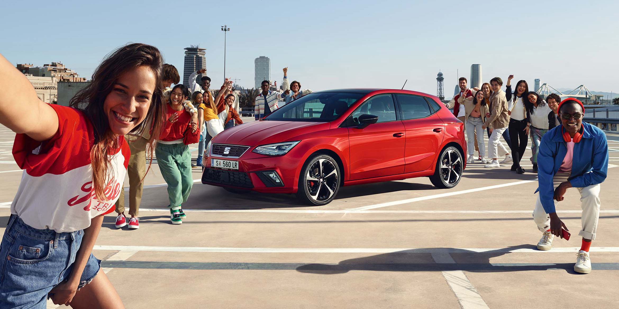 Freunde feiern eine Party, in der Mitte steht ein roter SEAT Ibiza.