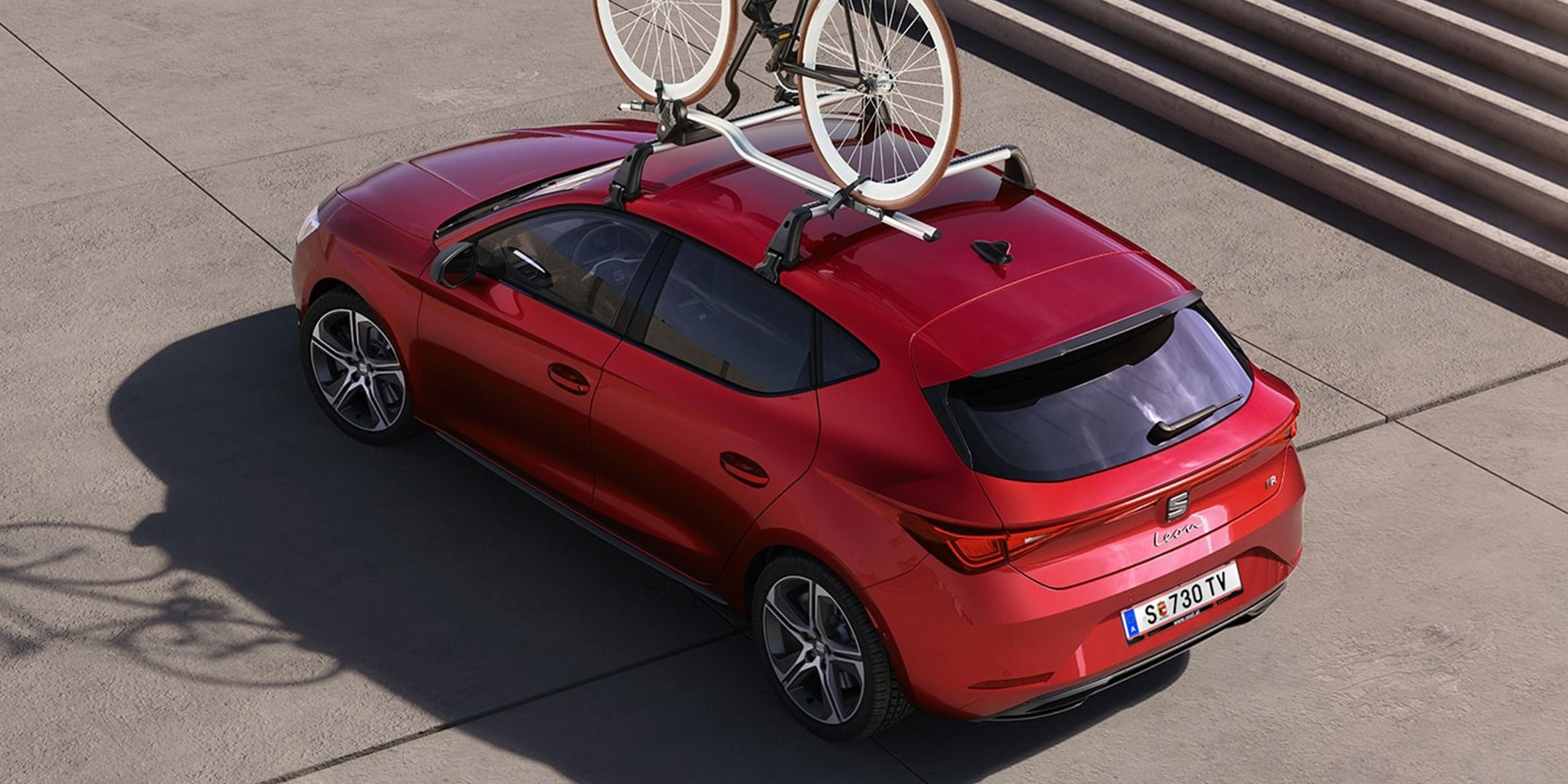 Ein SEAT Leon mit montierten Dachträgern, auf denen ein Fahrrad befestigt ist