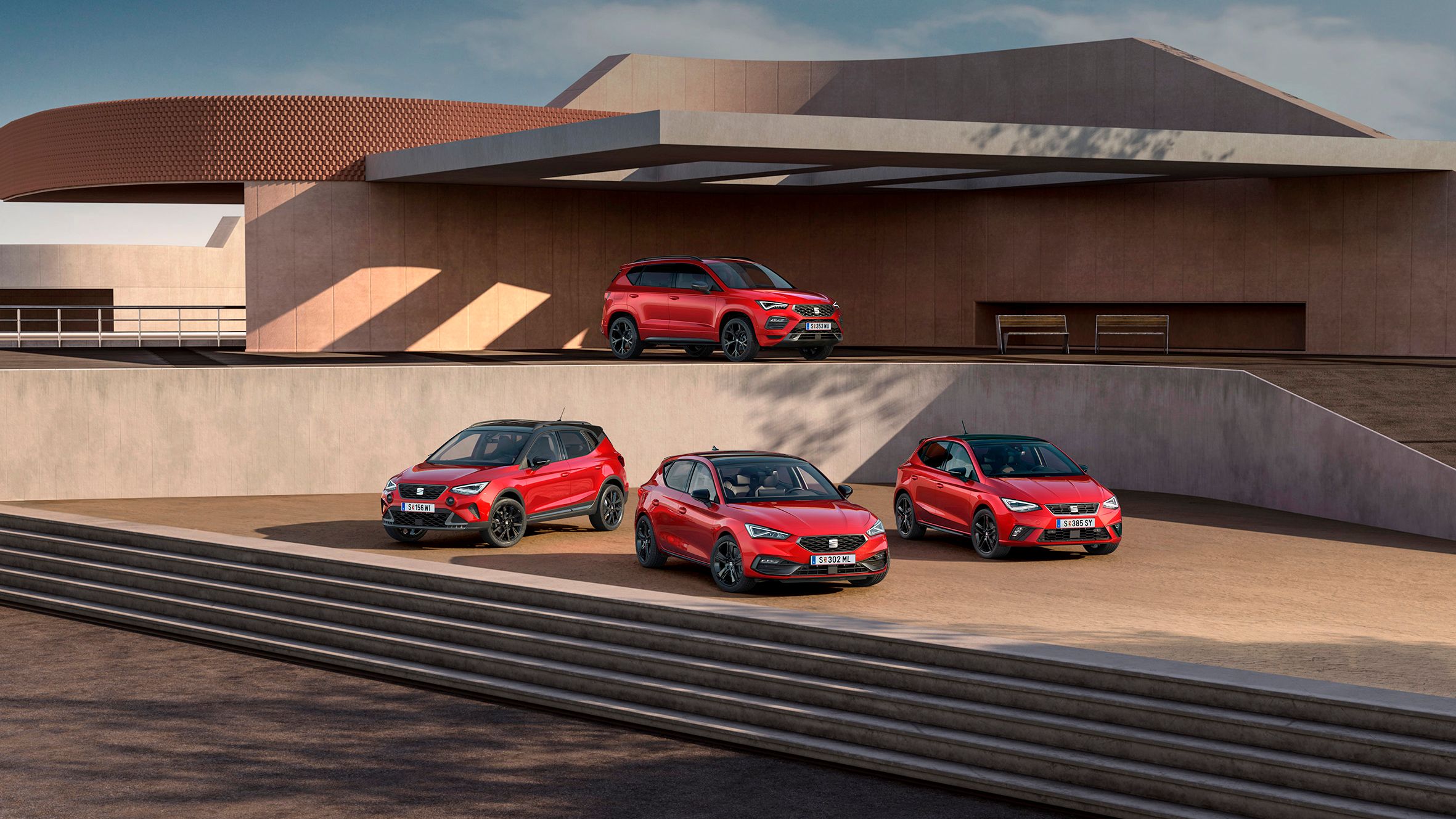 SEAT Black Edition Range shooting, sind vor einem zweistöckigen öffentlichen Gebäude mehrere Modelle zu sehen: Im unteren Bereich stehen der Arona, der Leon und der Ibiza, während auf der oberen Etage der Ateca positioniert ist