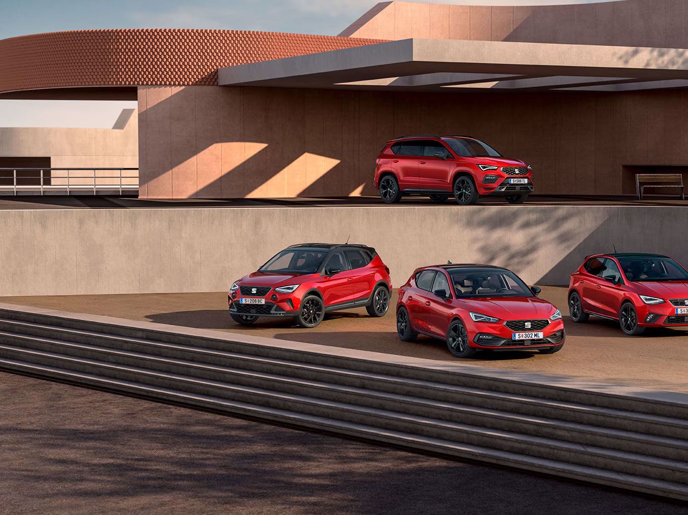 SEAT Black Edition Range shooting, sind vor einem zweistöckigen öffentlichen Gebäude mehrere Modelle zu sehen: Im unteren Bereich stehen der Arona, der Leon und der Ibiza, während auf der oberen Etage der Ateca positioniert ist