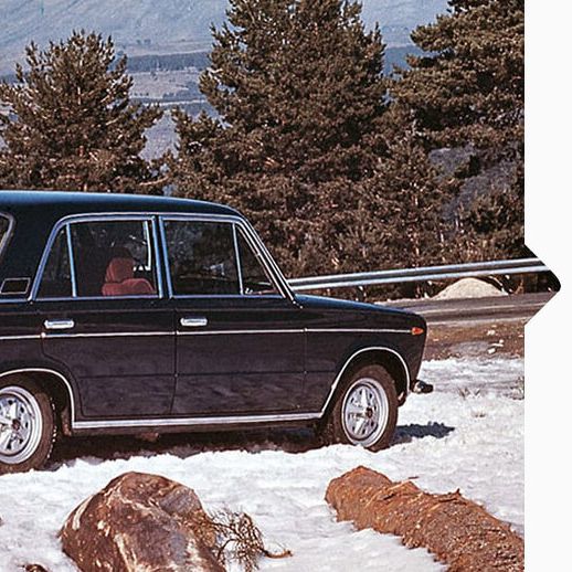 Ein schwarzer SEAT 124 aus den Jahr 1964 parkt im Schnee an einer Bergstraße.