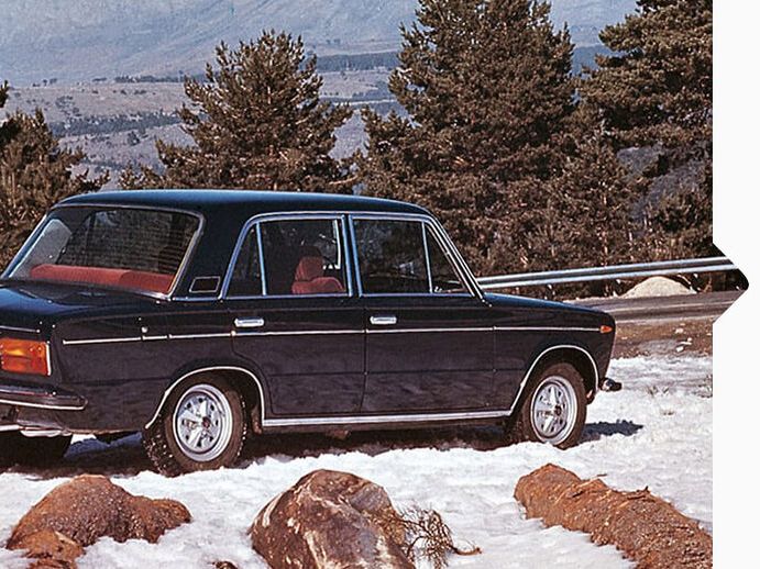 Ein schwarzer SEAT 124 aus den Jahr 1964 parkt im Schnee an einer Bergstraße.