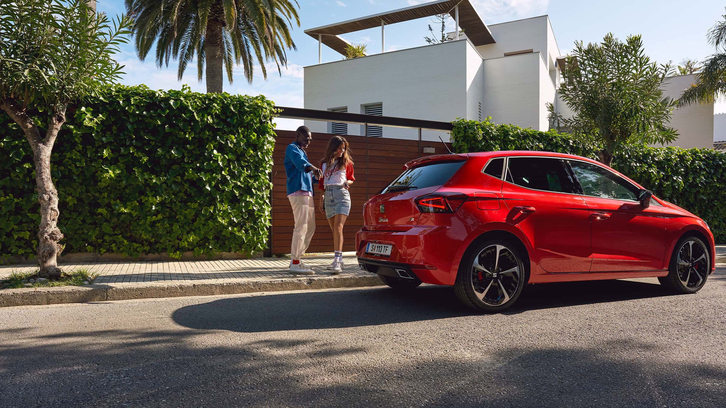 Paar betrachtet einen SEAT Ibiza in der Farbe Rot