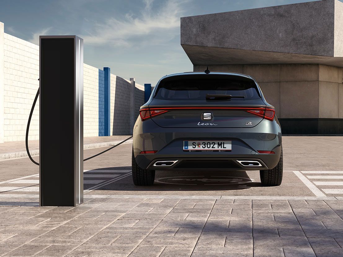 SEAT Leon Hybrid in der Lackierung Magnetic Tech beim Aufladen an der Ladestation