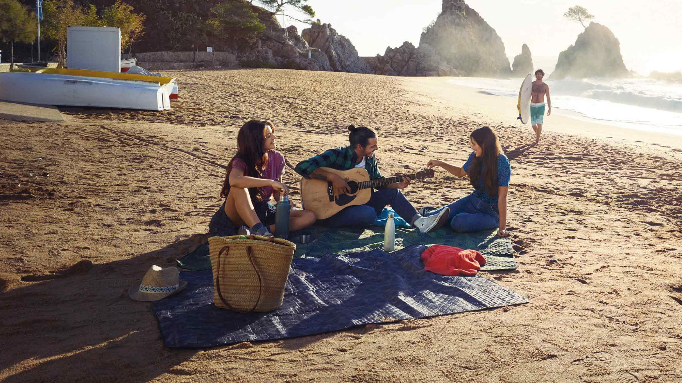 Zu sehen ist eine Gruppe junger Leute am Strand