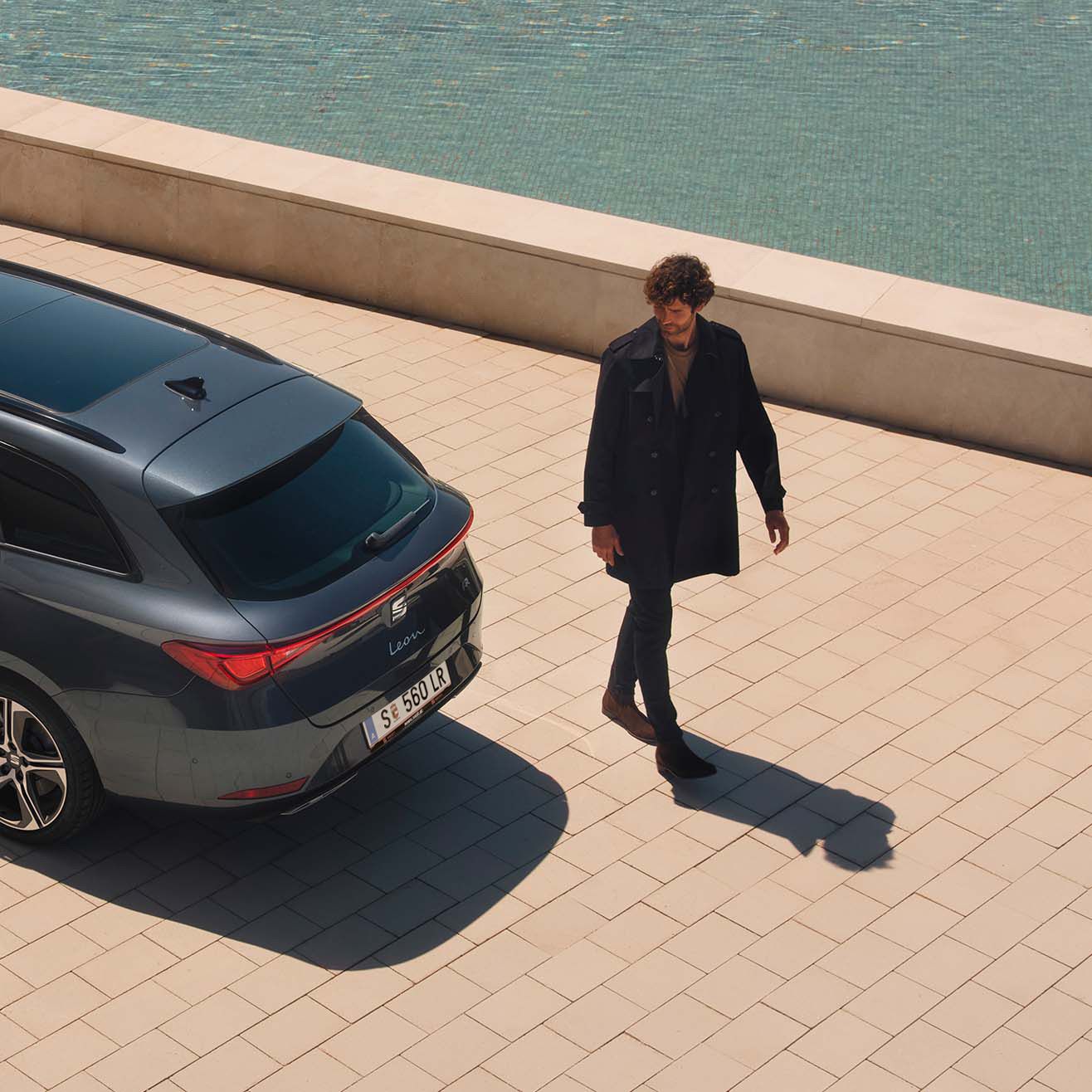 Homem a observar a costa junto ao SEAT Leon Sportstourer
