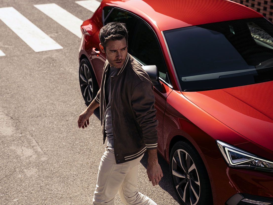 Mann entfernt sich von roten SEAT Leon