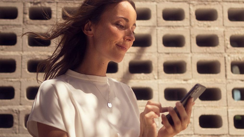 Frau mit ihrem Smartphone, verbunden mit SEAT Connect