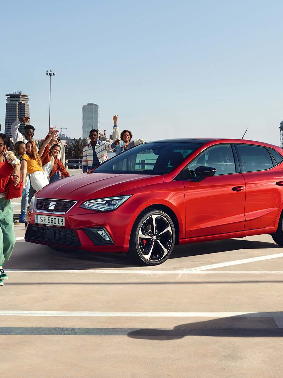 Freunde feiern eine Party, in der Mitte steht ein roter SEAT Ibiza.