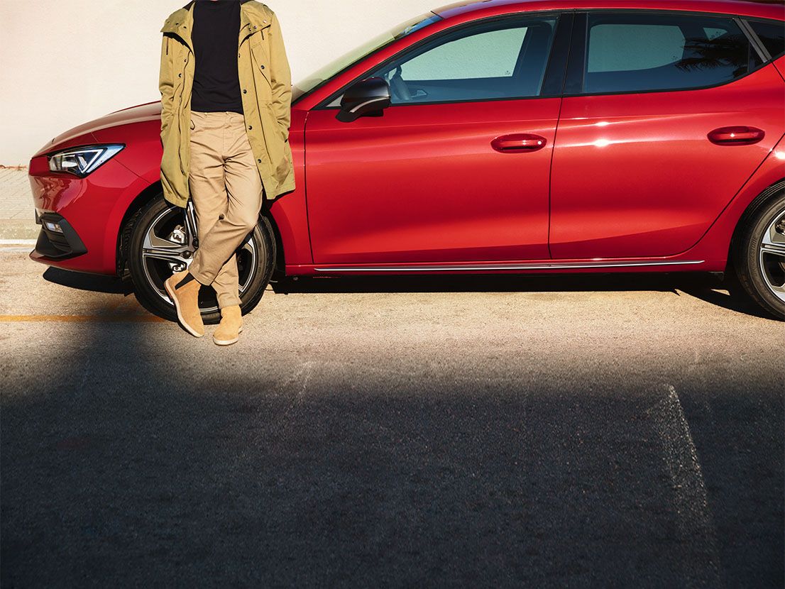 Homem junto ao SEAT Leon Sportstourer em vermelho desire