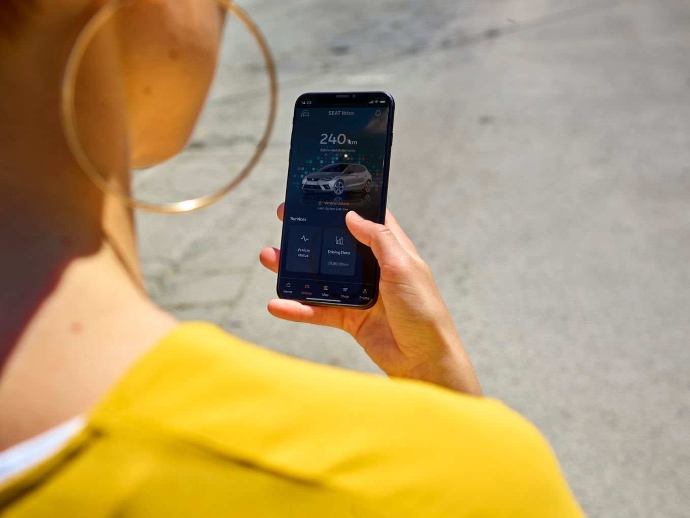 Eine Frau hält ihr Smartphone in der Hand und nutzt gerade SEAT Connect