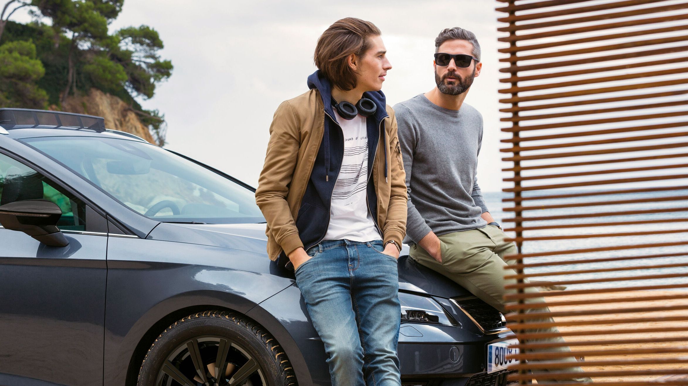 Zwei Männer lehnen an der Motorhaube eines SEAT und unterhalten sich 