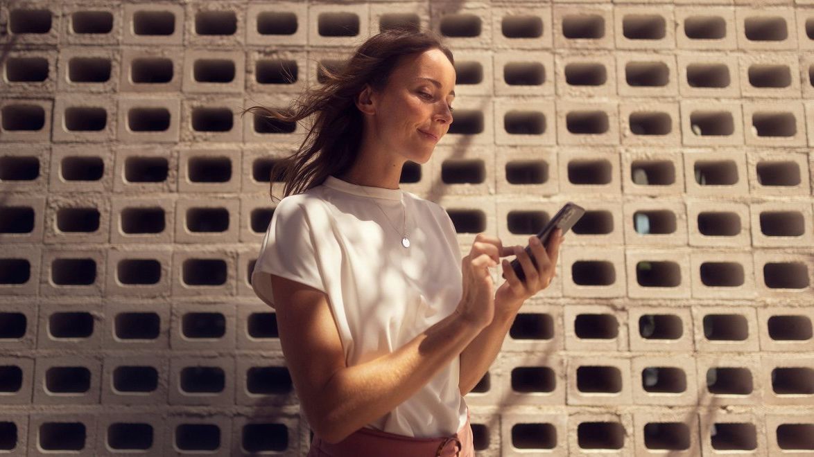 Frau mit ihrem mit SEAT CONNECT verbundenen Smartphone