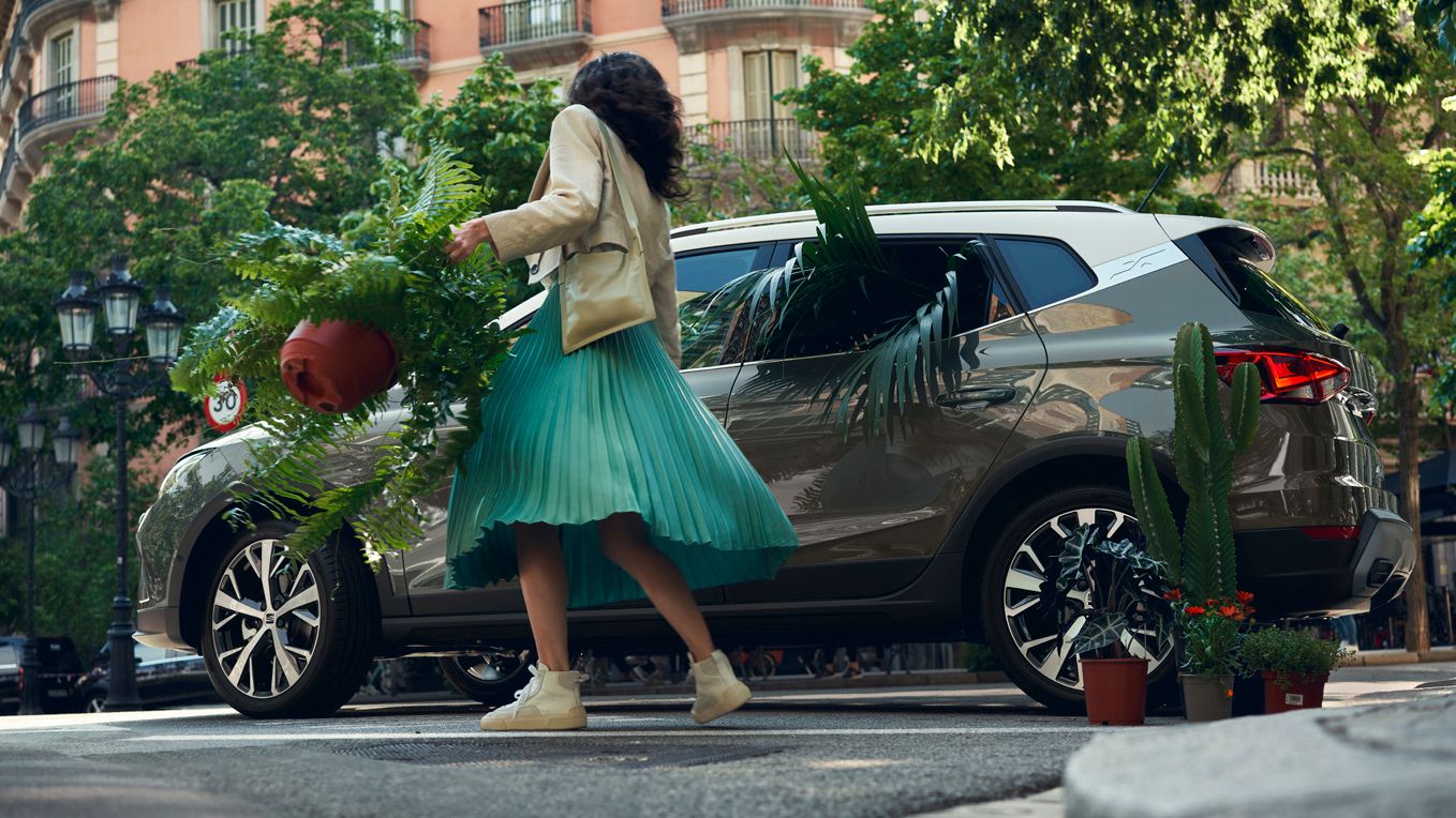 Eine Frau öffnet die Tür eines SEAT Arona