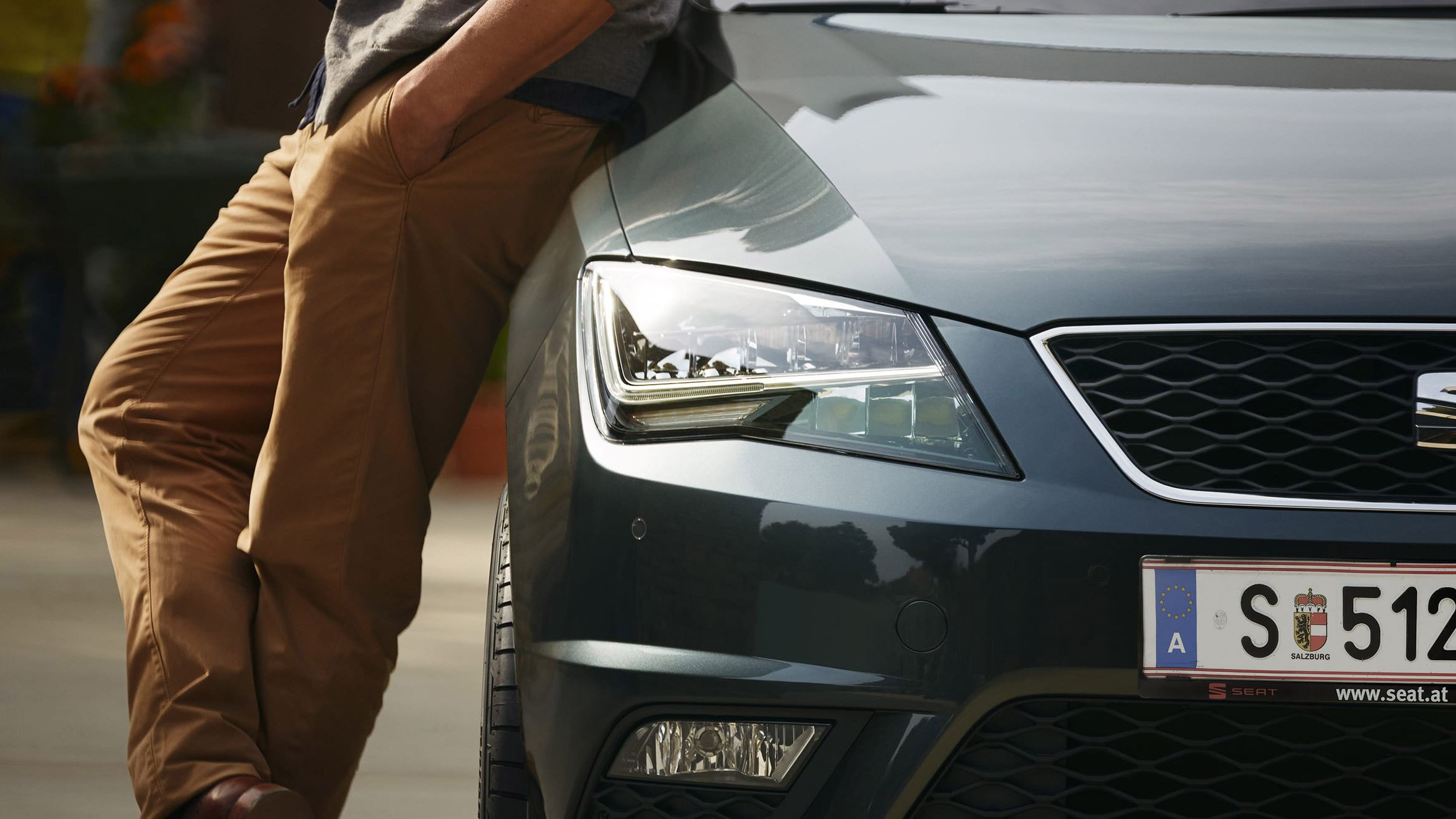 Ein Mann lehnt an der Motorhaube eines SEAT