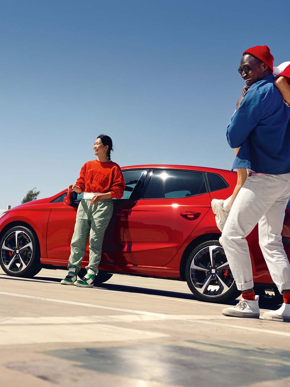 Freunde stehen vor einem roten SEAT Ibiza