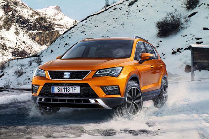 Ein SEAT Ateca fährt auf einer beschneiten Straße 