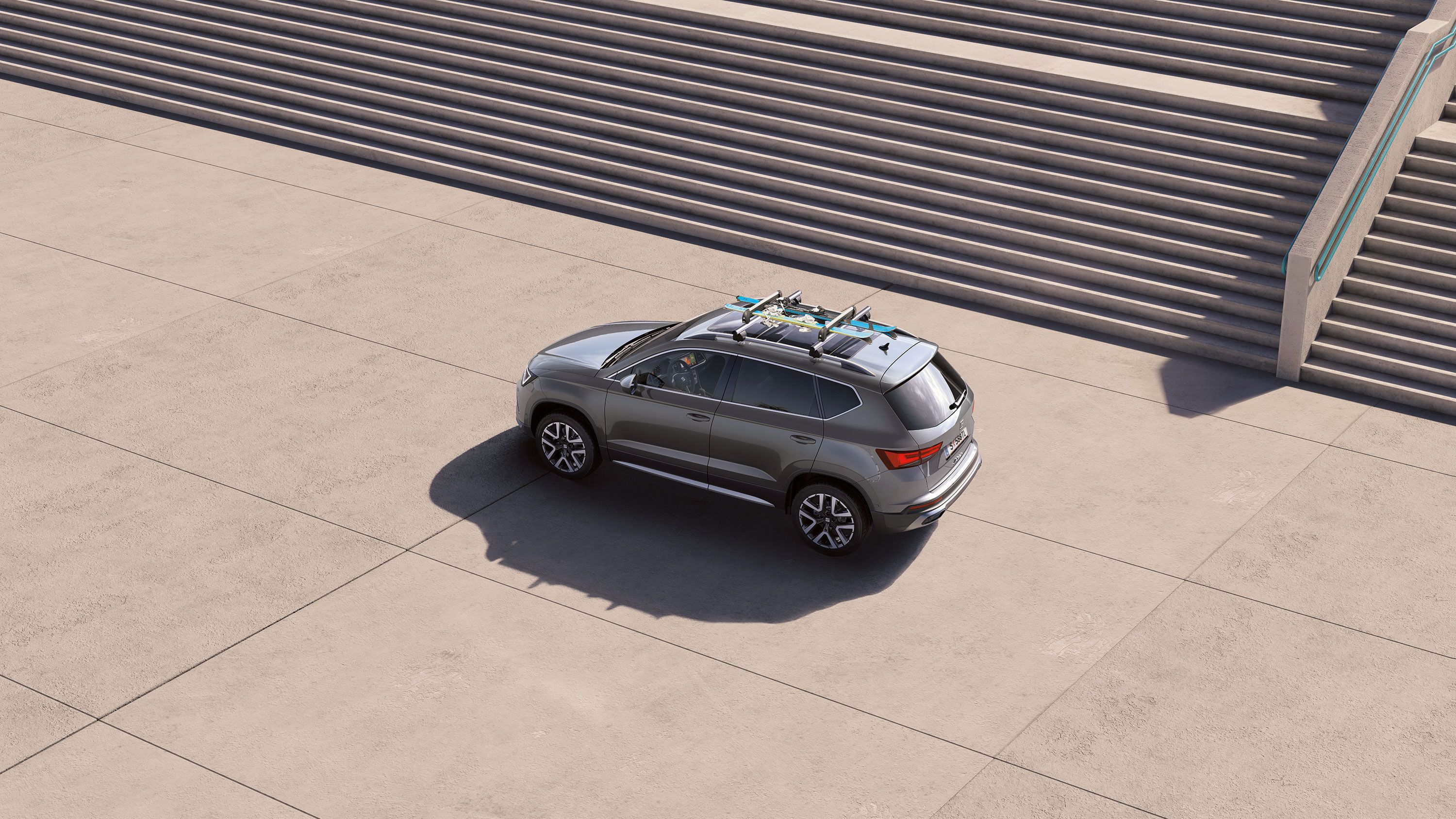 Ein SEAT Ateca mit Dachträger, auf dem zwei Snowboards befestigt sind