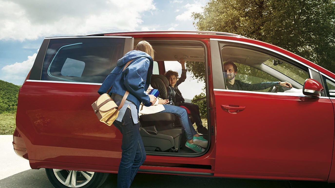 Eine Familie sitzt in einem roten SEAT Alhambra